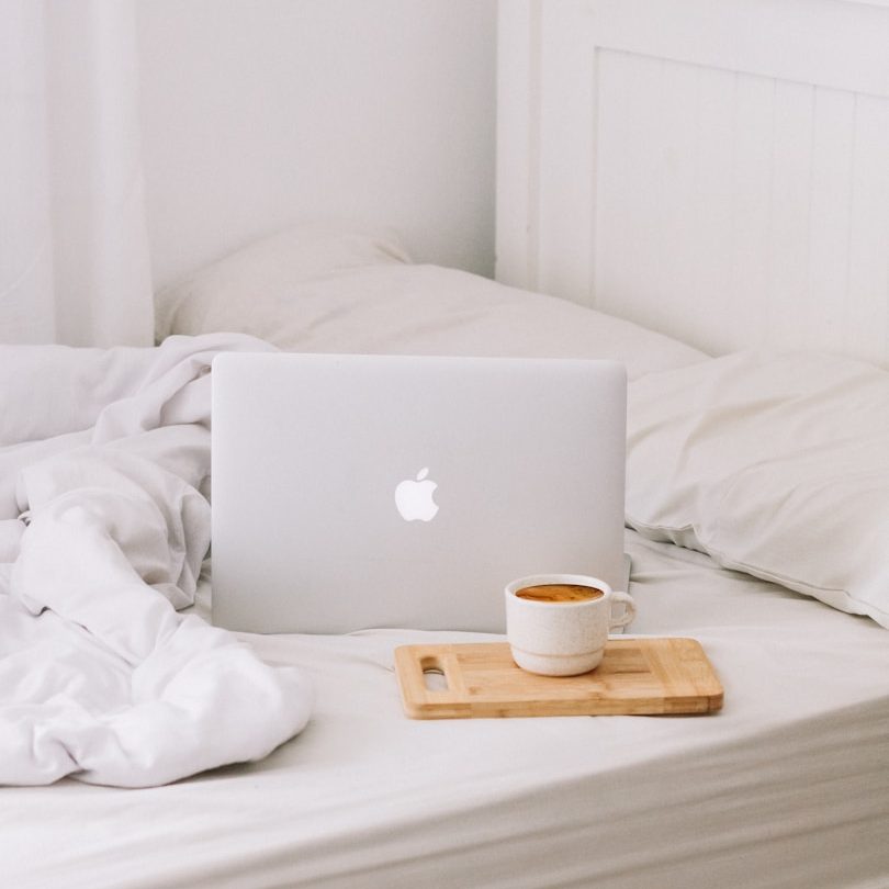 Ein Laptop und eine Tasse Kaffee im Bett 